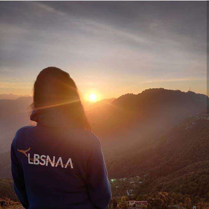 a person standing on top of a mountain looking at the sun