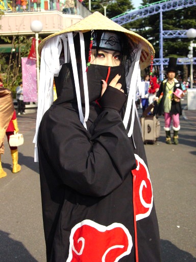 a person wearing a black and red outfit is talking on a cell phone while standing in the street