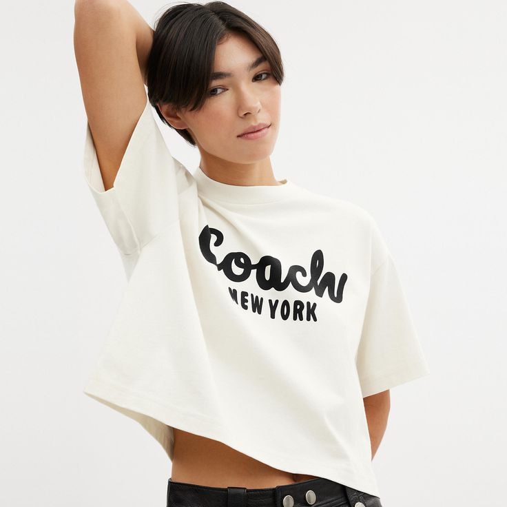 Detailed with our cursive Coach script this cropped T-shirt is crafted of soft cotton. The boxy silhouette features a comfortable easy to wear dropped shoulder. | Coach Cursive Signature Cropped T-Shirt - Women's Size Small - Cream Logo Print Cropped T-shirt For Spring, Cropped Logo Print T-shirt For Spring, Spring Cropped T-shirt With Logo Print, Boxy Fit Logo Print Top, Spring Logo Print Crop Top, Cotton Cropped Shirt With Logo Print, Sporty Cropped Top With Logo Print, Spring Graphic Tee With Logo Print, Spring Graphic Tee Cropped T-shirt With Logo Print