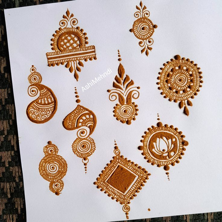 hendi tattoos are arranged on top of a piece of white paper with brown designs