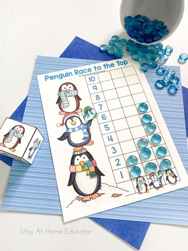 a penguin race to the top game with blue gummy candies next to it