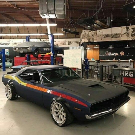 an old muscle car parked in a garage