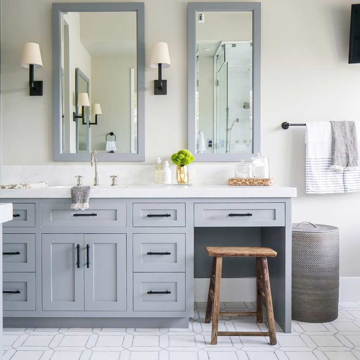 a bathroom with two sinks, mirrors and stools in front of the vanity area