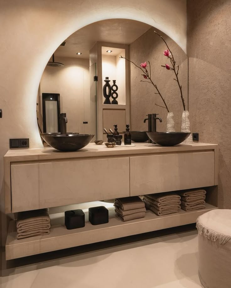 a bathroom with a sink, mirror and vase on the counter top in front of it