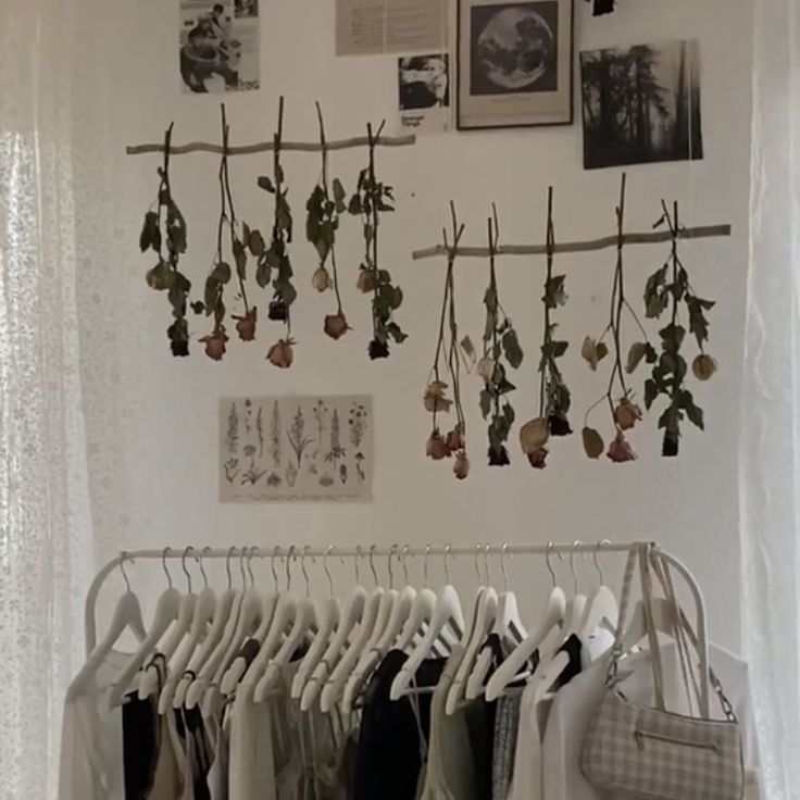 there is a rack with clothes hanging on the wall and pictures above it, along with other items