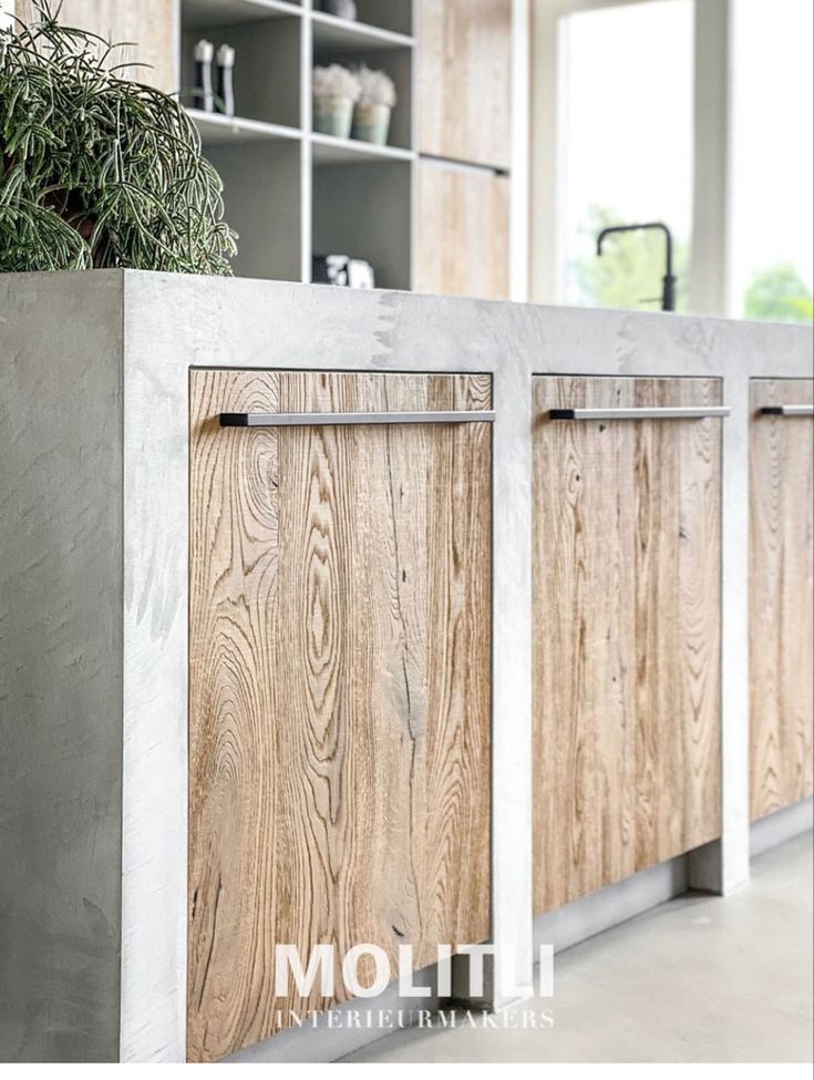 a kitchen with wooden cabinets and plants in the center, along with white tile flooring