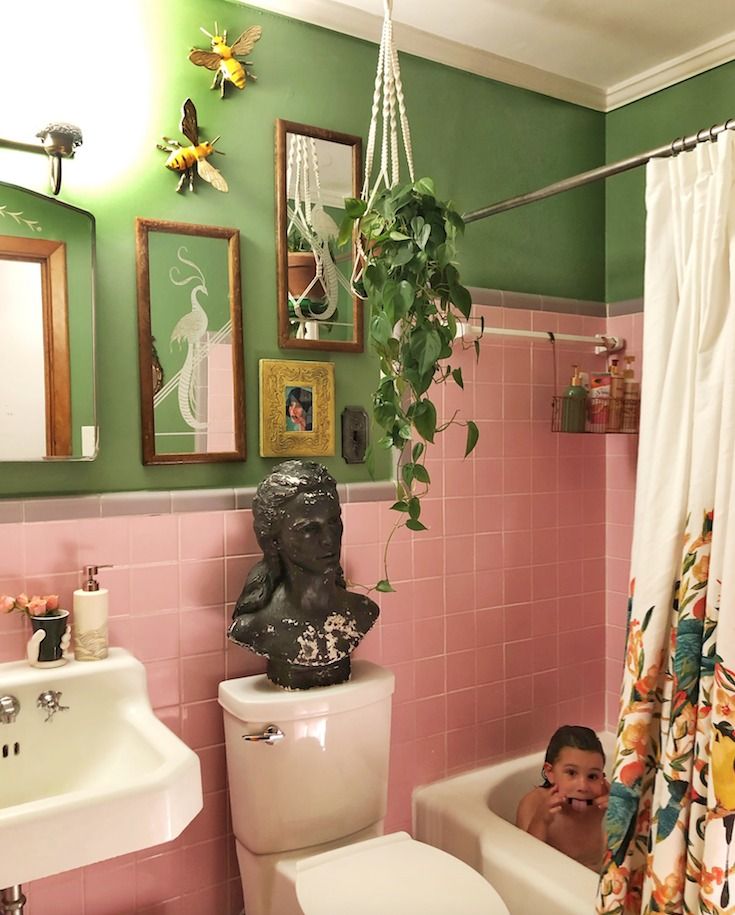 a bathroom with pink and green walls, a white toilet and bathtub next to a shower curtain