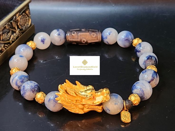 Gift yourself or your loveonce this beautiful exquisite Pure Gold Dragon Bracelet.  *Materials: Au999 Pure Gold, Dumortierite, and Obsidian Stone.  *Karat: 24K Pure Gold  *Gold Color: Yellow *Stone Size: 10mm *Gold Mass: Approximately 4.22g *Dragon length:  Approximately 1.09 Inch *Tibetan Dzi Stone: Approximately 10x22mm 💢 The dragon ia the male element of yang, it represents good luck, fortune, strength, and health. ●Metal is made of Pure Gold only. NOT gold filled, NOT Gold plated, NOT gold vermeil. Hollow. Hallmarked.  💥PLS FOLLOW US AND CHECK OUR OTHER LISTINGS. WE HAVE NEW STOCKS LISTED DAILY/WEEKLY.  📬S H I P P I N G WE SHIP WITHIN 24 HOURS. Free shipping in the US and International orders. Gold Spiritual Crystal Bracelet For Gift, Spiritual Gold Bracelet With Round Beads As Gift, Gold Bracelets With Round Beads For Celebration, Gold Spiritual Crystal Bracelet For Wedding, Luxury Bracelets For Festivals As Gifts, Gold Bracelet With Round Beads For Birthday Gift, Luxury Bracelets For Festivals Gift, Gold Beaded Bracelet For Birthday Gift, Luxury Gold Bracelet With Round Beads For Gift