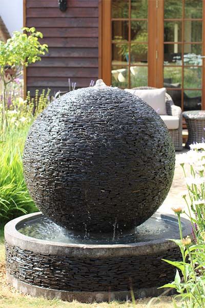 an outdoor fountain in the middle of a garden