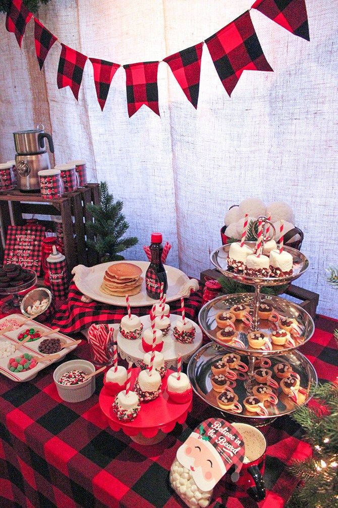 a table topped with lots of desserts and pastries next to a christmas tree