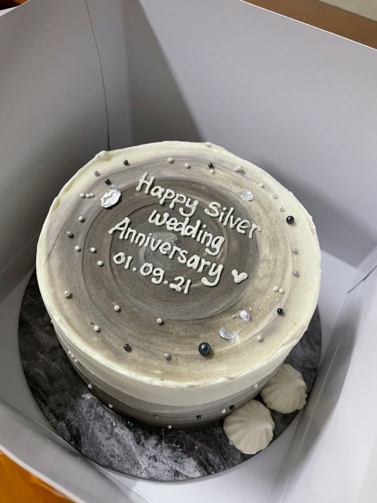 a birthday cake in a box with the words happy silver wedding anniversary written on it