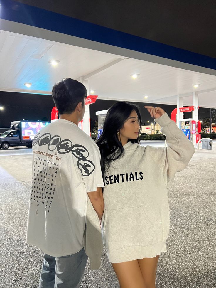 a man and woman standing next to each other at a gas station