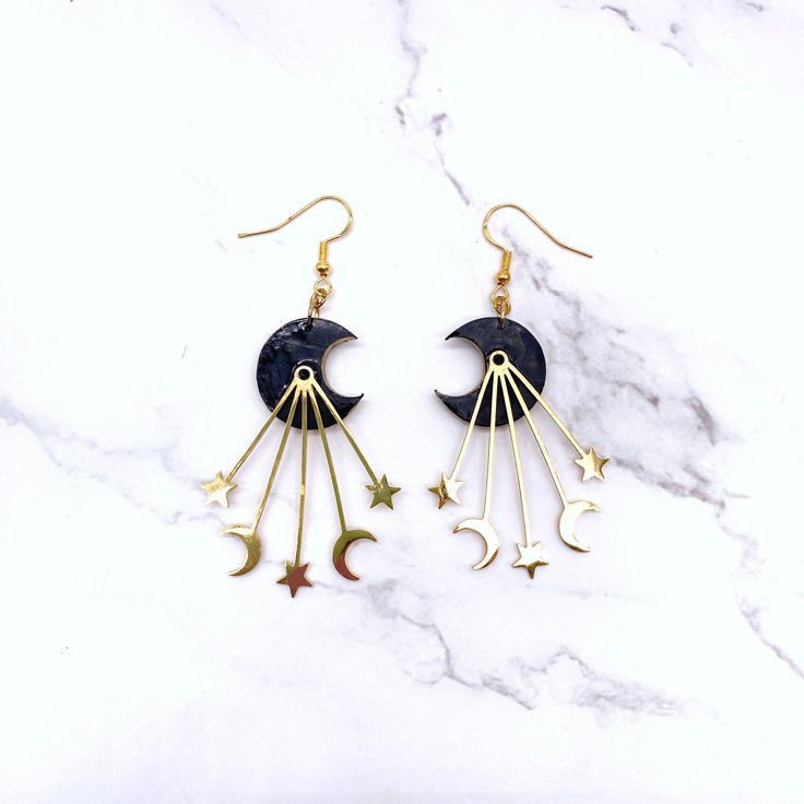 Dance with the Stars: Black & Gold Moon Wire Hook Earrings (Gift for Her) ✨Embrace the celestial spirit with these enchanting Black & Gold Moon Wire Hook Earrings! A captivating addition to your jewelry collection, this pair features a pair of black crescent moons adorned with shimmering gold accents.A perfect gift for the mystical woman in your life, these earrings embody the beauty and intrigue of the night sky. The lightweight design and comfortable hook closure with push backs ensure comfort Celestial Adjustable Pierced Earrings, Handmade Black Magical Jewelry, Handmade Magical Black Jewelry, Black Star-shaped Metal Earrings, Handmade Black Moon-shaped Earrings, Handmade Black Moon Earrings, Black Celestial Earrings For Gift, Moon Phase Star Earrings For Gift, Mystical Black Metal Earrings