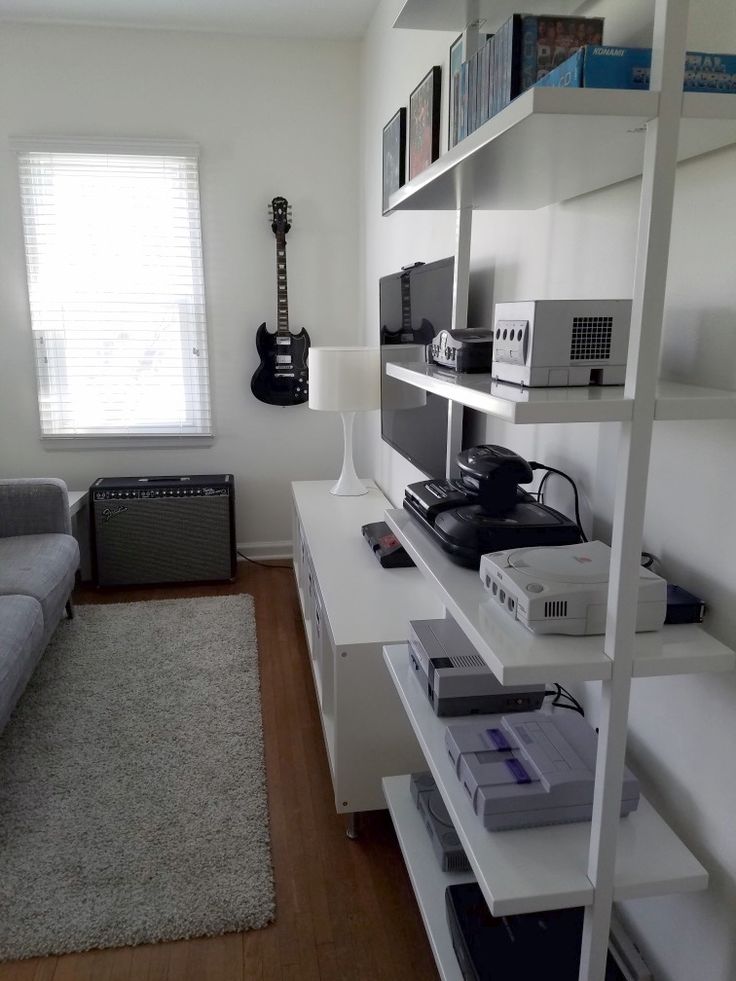 a living room filled with furniture and lots of white shelving unit units in front of a window