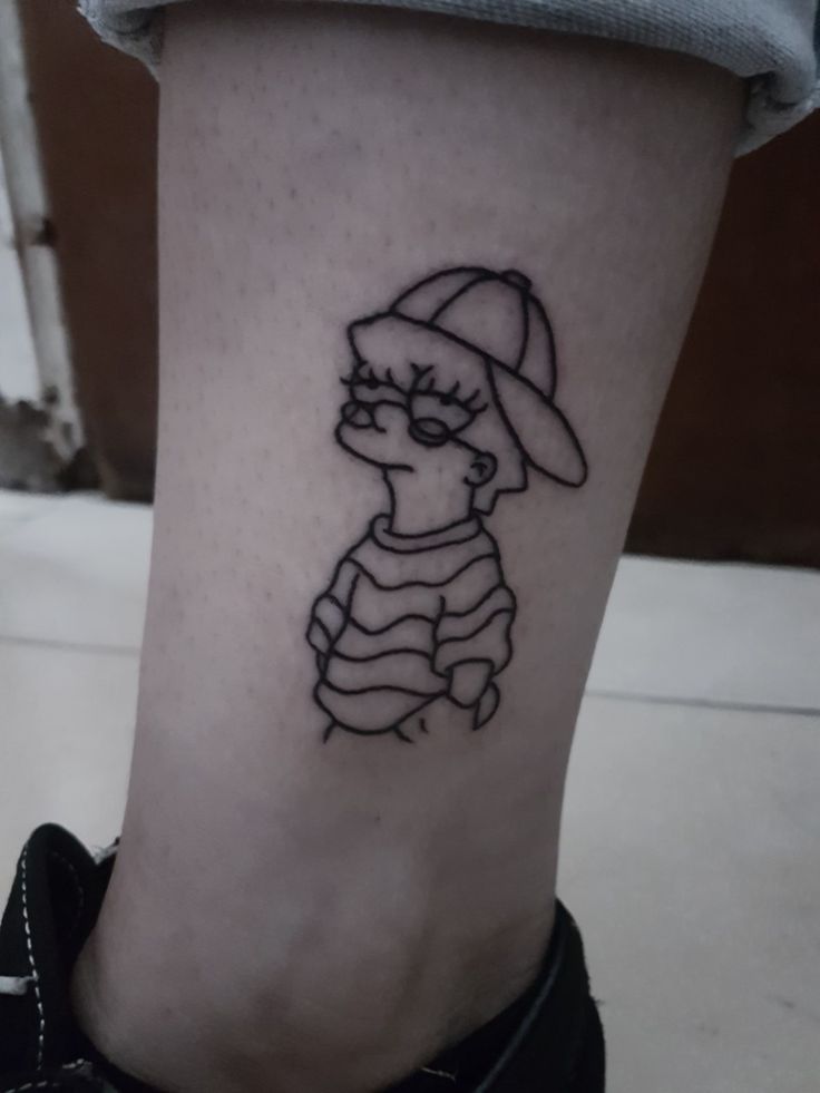 a person with a tattoo on their leg wearing a hat and striped shirt is sitting down