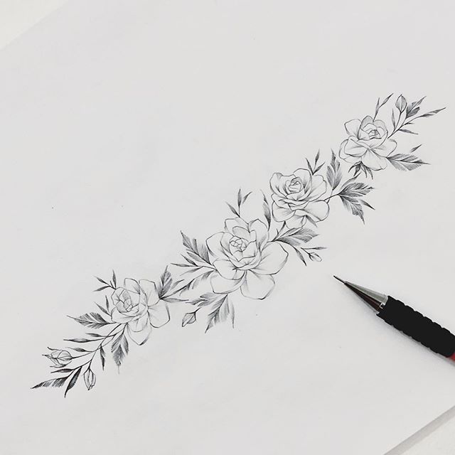 a pencil drawing with flowers and leaves on the side of a sheet of white paper