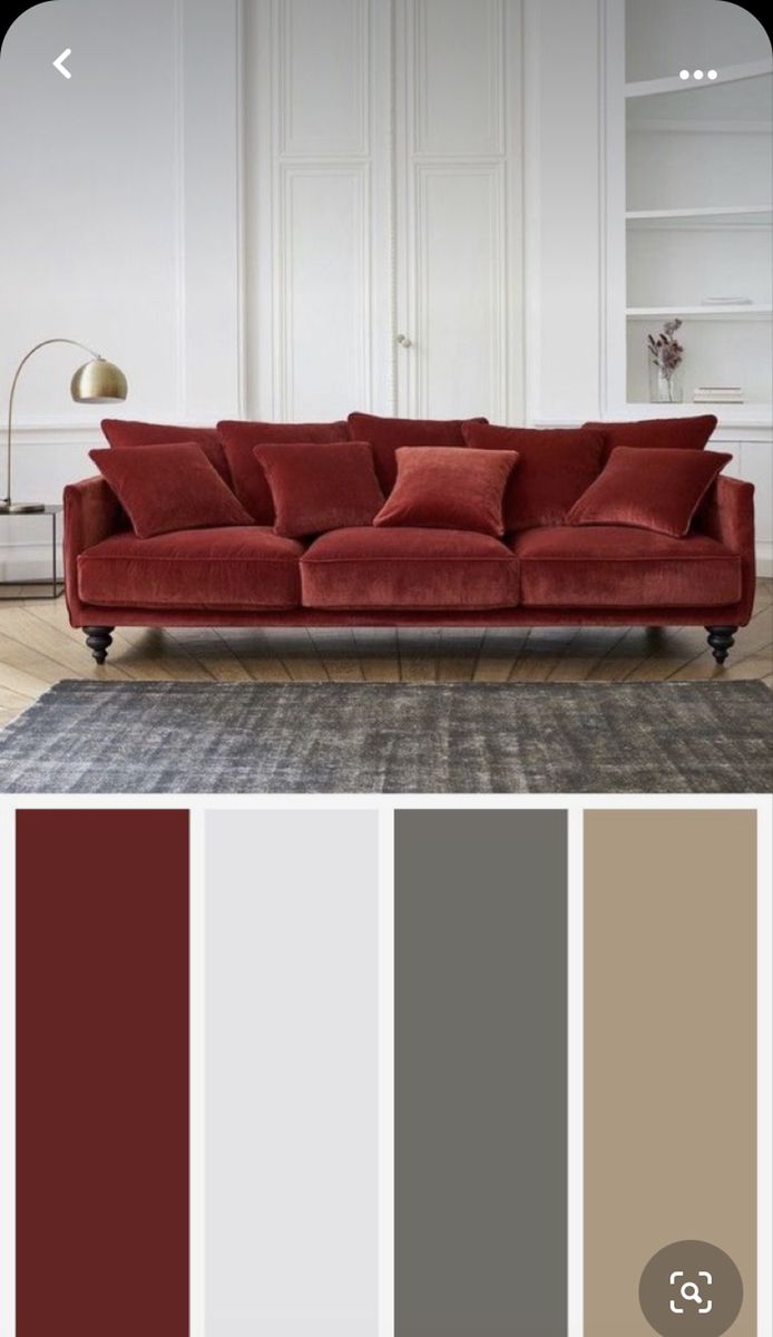 a living room with red couches and grey rugs on the floor, in front of white walls