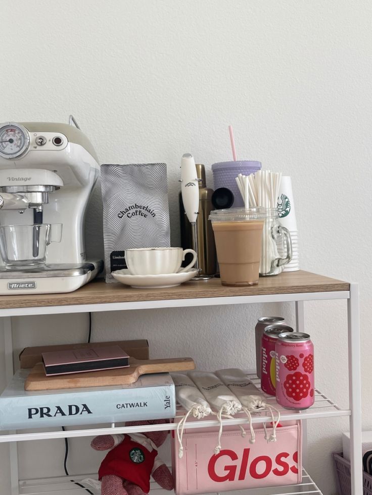 a shelf filled with books and appliances on top of a white wall next to a coffee maker