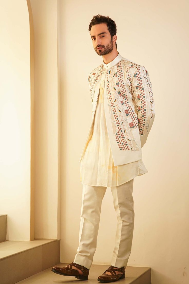 Editor's Note Featuring Our Bestseller Short Jacket, Now In A Dirty Ivory Color. Paired With A Champagne Marble Dyed Kurta And Tapered Trousers, Is Our Four Level-paneled Hand Embroidered Short Jacket Set, Inspired By Pablo Picasso's Cubism Artwork. Fabric: Linen Silk Color: Ivory Component: Short Jacket, Kurta. Trousers Care: Dry Clean Only About the Designer After establishing himself as the leading couturier in the industry of menswear, Jatin Malik went on to explore luxury footwear. You can Cream Long Sleeve Nehru Jacket For Festive Occasions, Beige Long Sleeve Bandhgala With Chikankari Embroidery, Designer Cream Nehru Jacket With Long Sleeves, Cream Nehru Jacket With Resham Embroidery Long Sleeve, Cream Long Sleeve Nehru Jacket With Resham Embroidery, White Sets For Fall Wedding, Cream Fitted Long Sleeve Nehru Jacket, White Wedding Sets For Fall, White Chikankari Embroidery Long Sleeve Outerwear