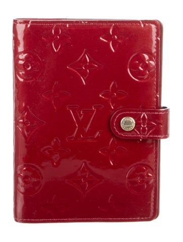 a red louis vuitton passport case with the initials on it and an embossed