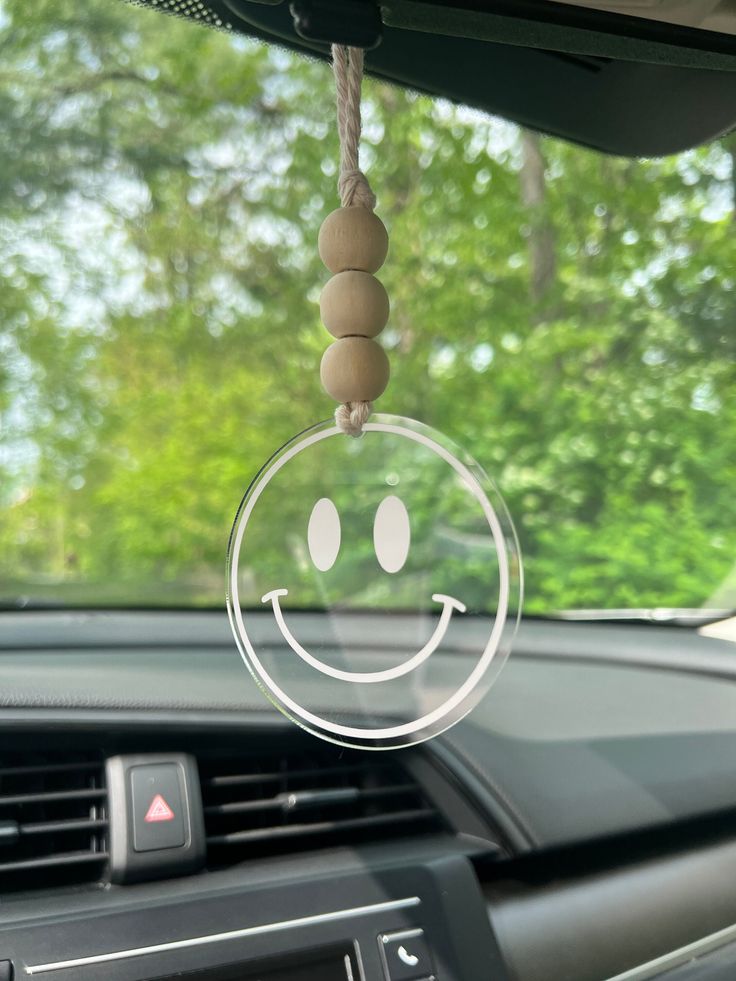 a car dashboard with a smiley face hanging from it