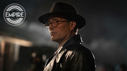 a man wearing glasses and a hat in the dark