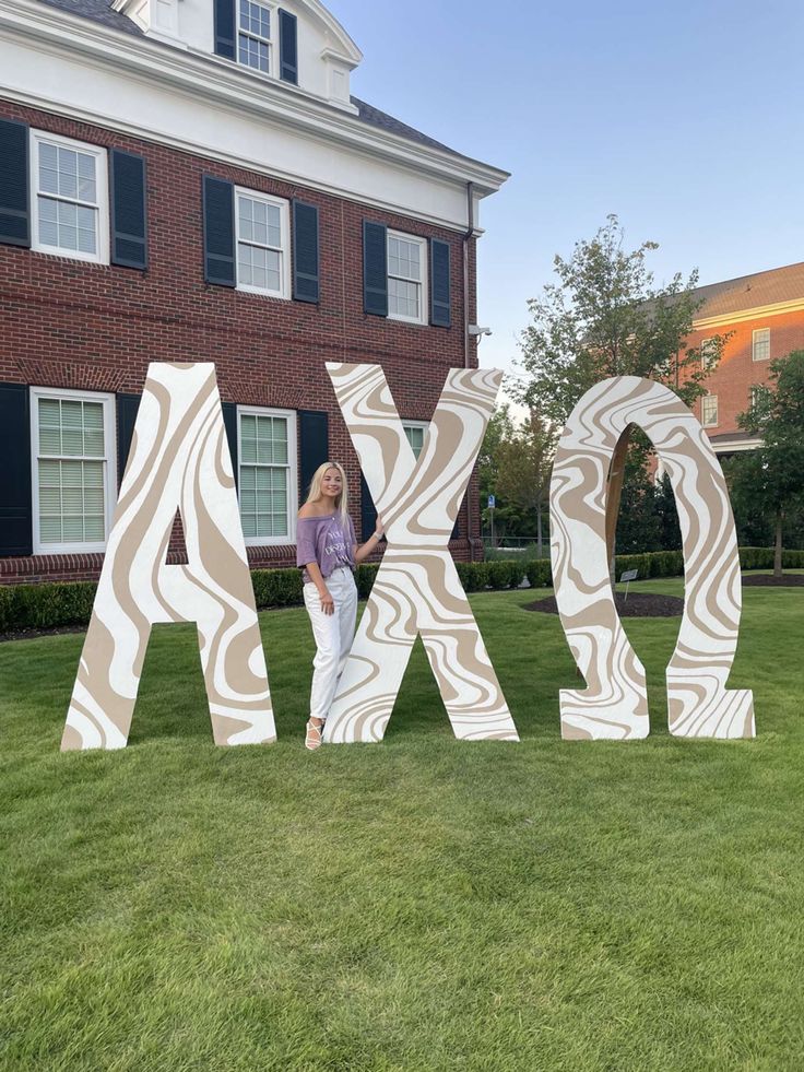 a woman standing in front of the letters that spell out ajax