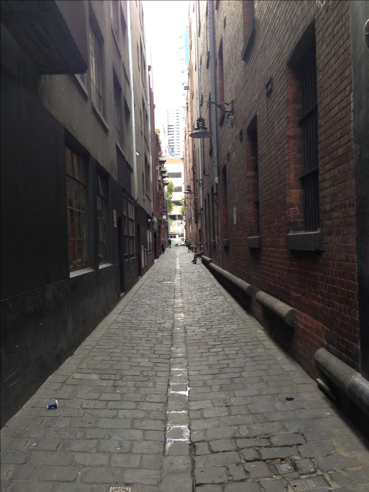 an alley way in the city with brick buildings