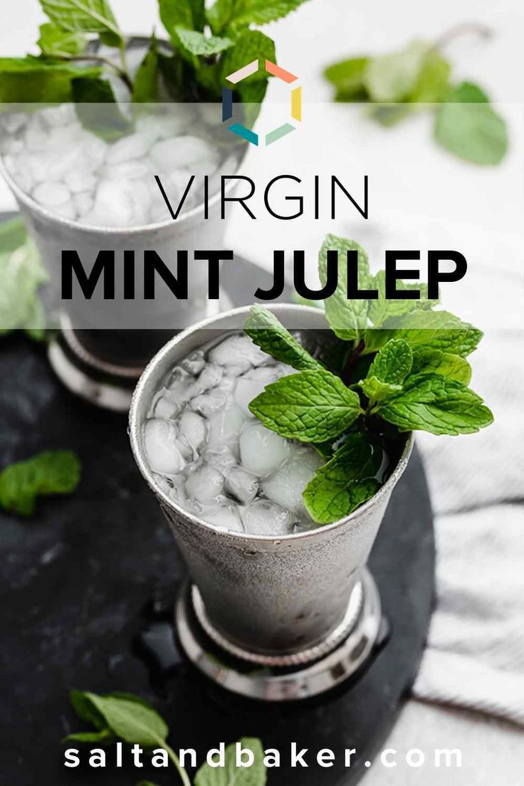 two silver cups filled with mint and ice on top of a black table next to each other