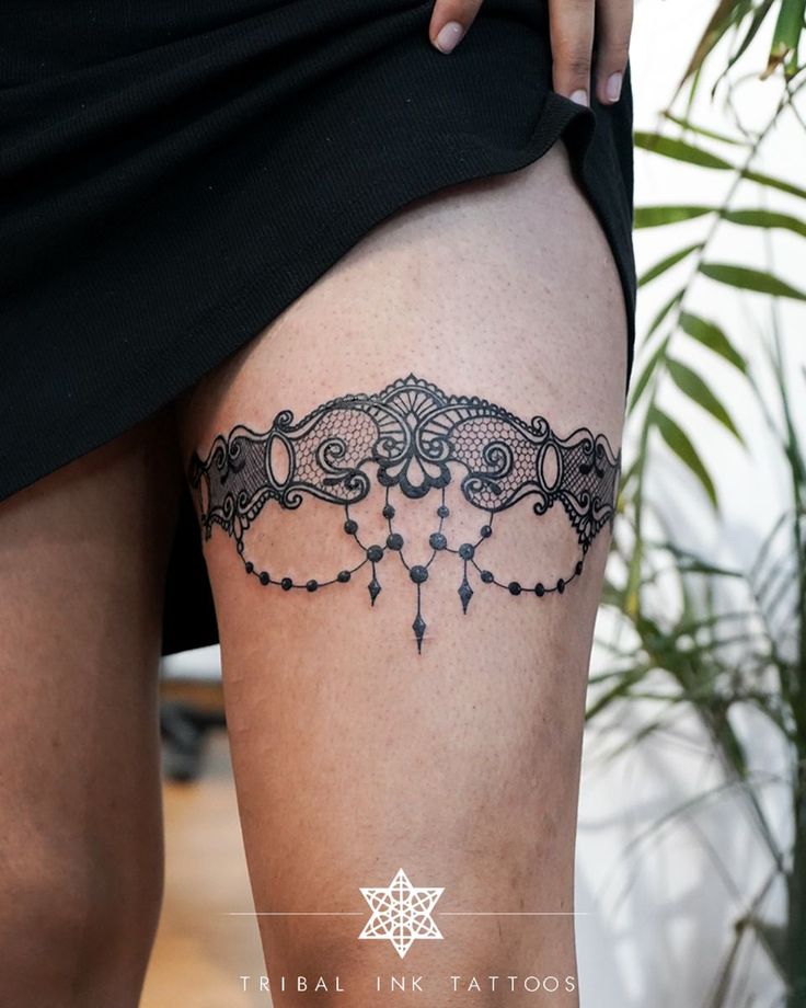 a woman's thigh with a tattoo design on the side and an ornamental motif