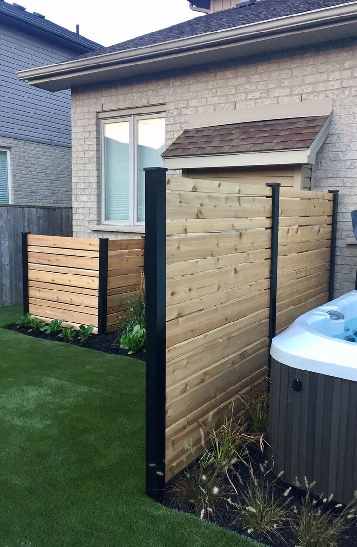 a hot tub sitting next to a wooden fence