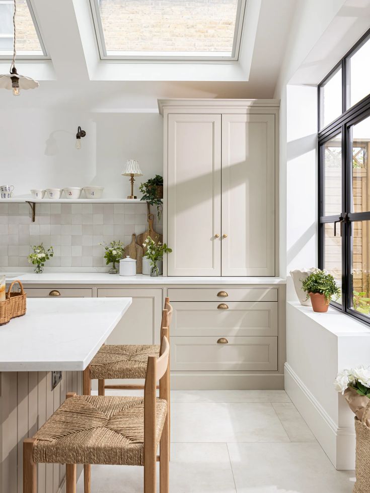 a kitchen with white walls and flooring has a skylight above the countertop