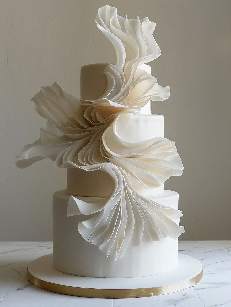 a three tiered white wedding cake on a marble table