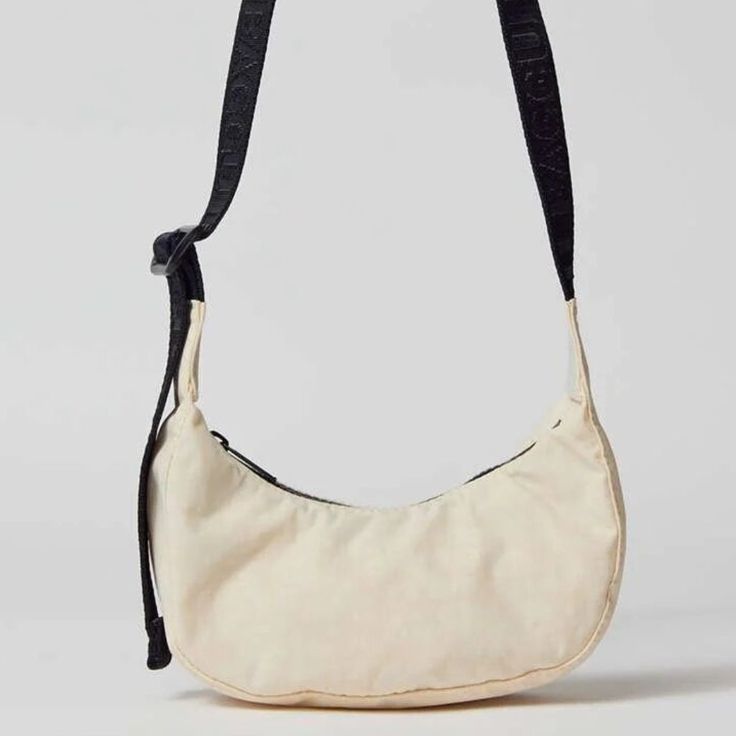 New With Tag. Color: Ivory Mini Version Of Baggu’s Nylon Crescent Bag, Perfect For Stashing Just The Essentials. With An Adjustable Tonal Logo Strap, It Wears Comfortably Across The Body Or On The Shoulder For A Hands-Free Experience. Complete With Two Interior Pockets That Make It Easy To Stay Organized. Made Of Recycled Heavyweight Nylon With A Recycled Ripstop Lining. Features - Zip Closure With An Adjustable Strap - 100% Recycled Nylon - Machine Wash Size - Dimensions: 8.25"L X 2.25"W X 4"H White Nylon Shoulder Bag With Detachable Strap, White Crossbody Hobo Bag For On-the-go, White Baguette Bag With Removable Pouch For Travel, Cream Baguette Bag With Adjustable Strap For Travel, White Crossbody Hobo Bag, Versatile White Baguette Bag With Removable Pouch, Everyday Cream Pouch Hobo Bag, White Hobo Bag For Everyday Use, White Nylon Shoulder Bag With Removable Pouch