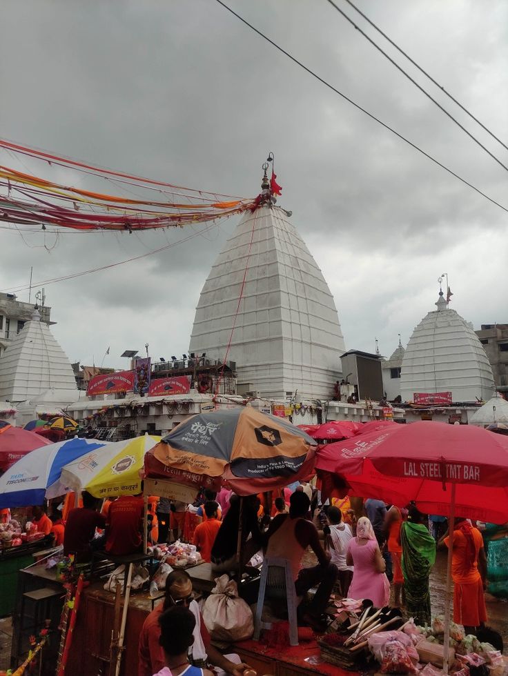 an outdoor market with umbrellas and other items