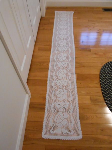 a white table runner sitting on top of a hard wood floor next to a door