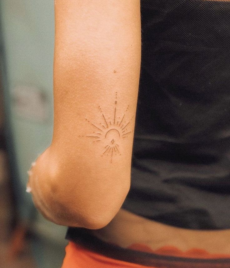 a woman with a sun tattoo on her arm