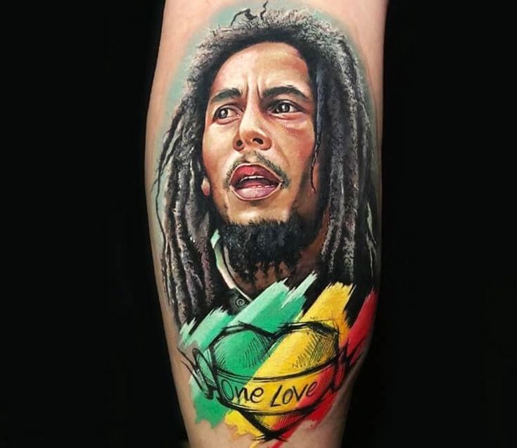 a man with dreadlocks and a heart tattoo on his leg