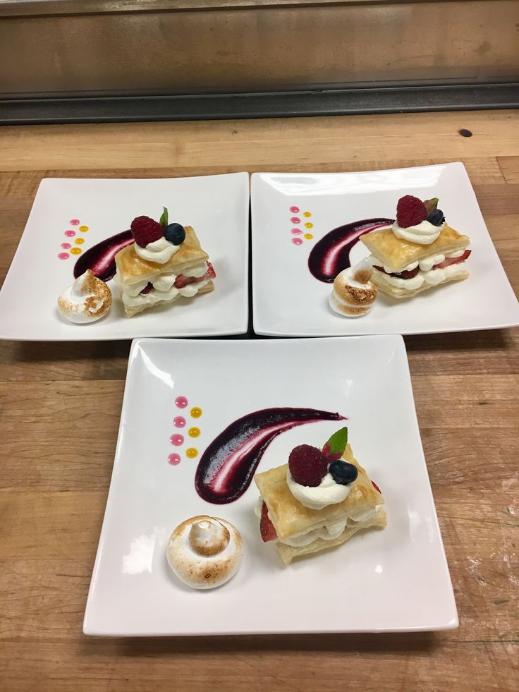 three white plates topped with desserts on top of a wooden table