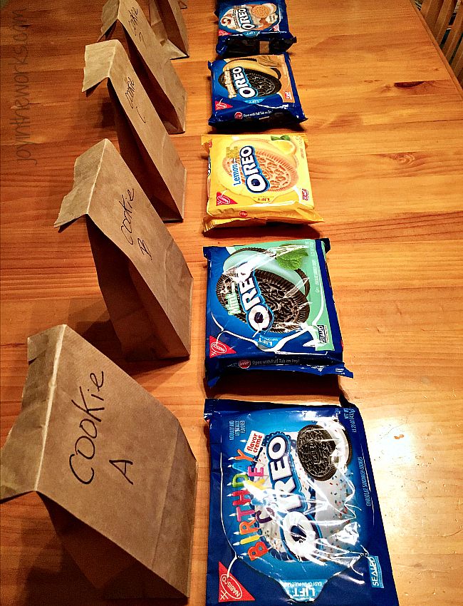 five bags of food sitting on top of a wooden table next to boxes with writing on them