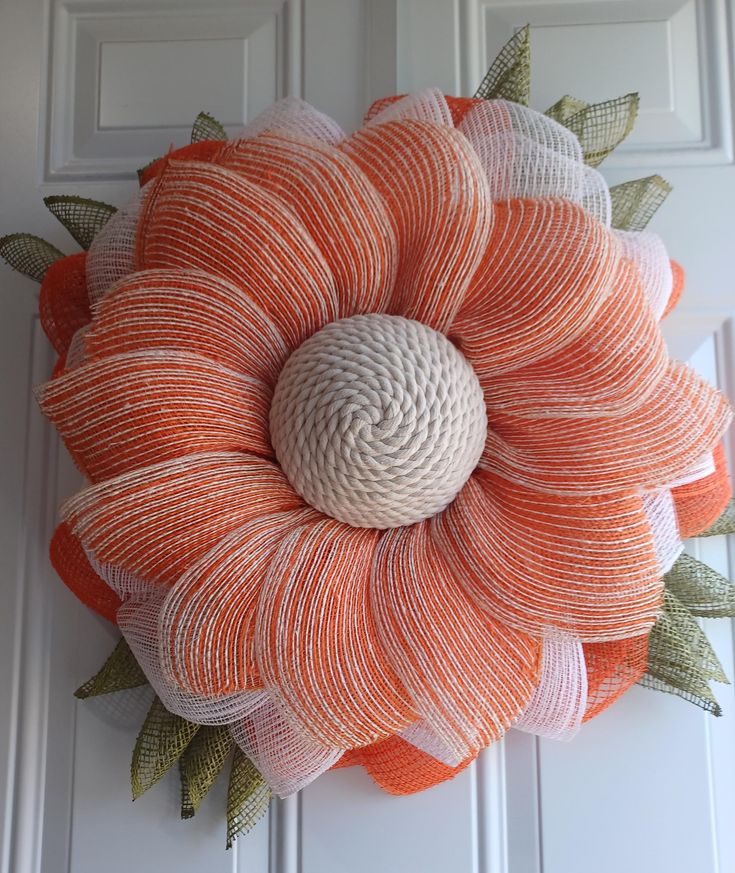 an orange and white flower made out of yarn