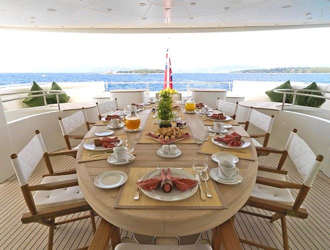 the dining table is set for two on the boat's upper deck, overlooking the ocean