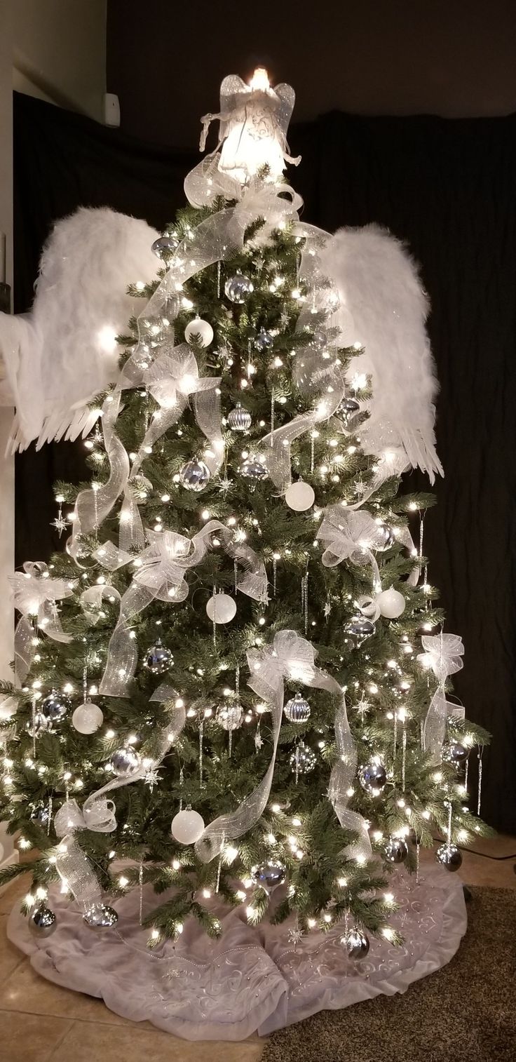 a christmas tree decorated with angel wings and ornaments