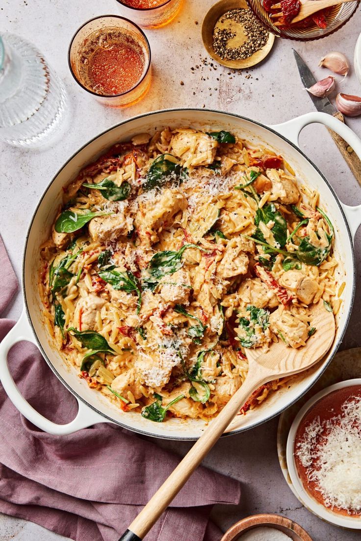 a pan filled with pasta and sauce on top of a table next to other dishes