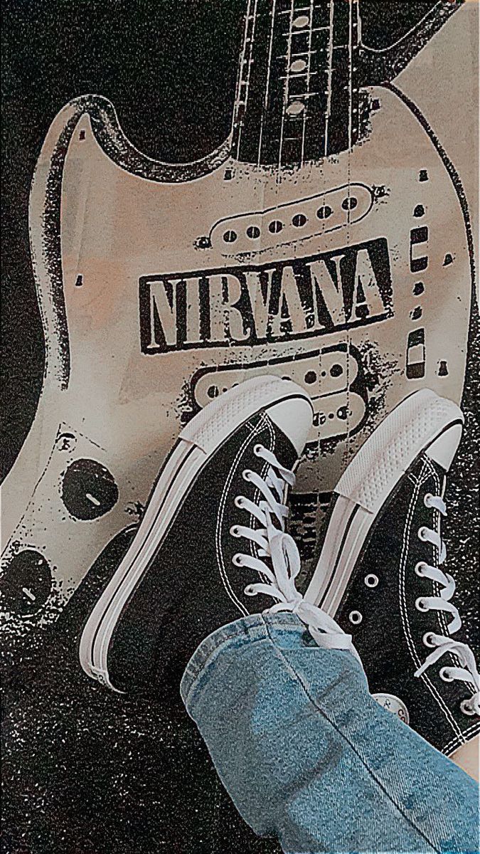 someone is standing next to a guitar with the words nirvana on it and their shoes are in front of them