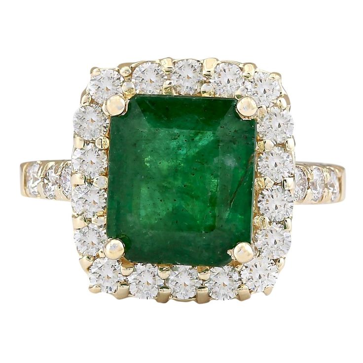 an emerald and diamond ring with two rows of diamonds around the band, set in yellow gold