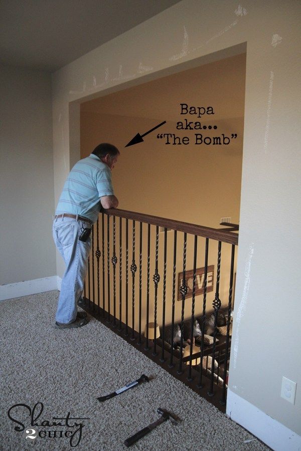 a man standing on top of a metal railing next to a dog in a cage