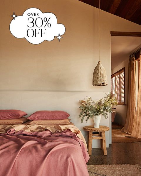 a bed room with a neatly made bed and a large white cloud on the wall