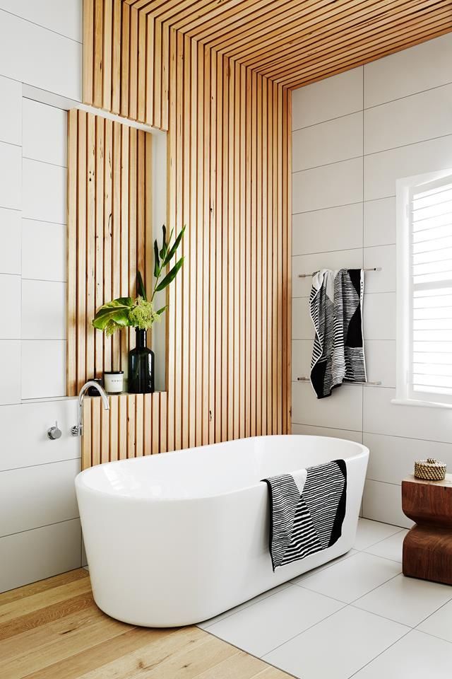 a white bath tub sitting on top of a wooden floor