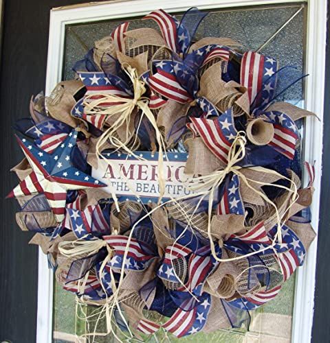 a wreath with the words welcome to friends on it and american flags hanging from the front door